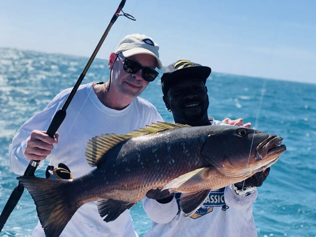 A Seakarus guide and guest holding their catch on the boat